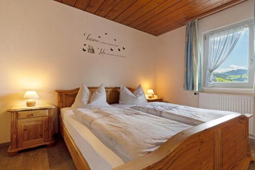 a bedroom with a large bed with white sheets and a window at Schwarzwaldliebe in Oberharmersbach