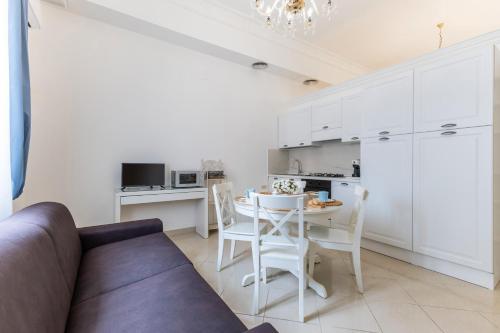 a living room with a couch and a table and a kitchen at Appartamento Achates in Acate