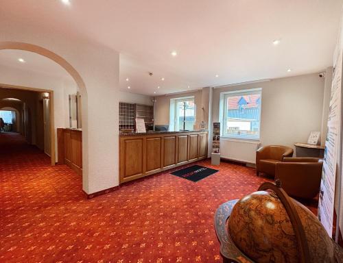 a hotel room with a waiting area and a lobby at REGIOHOTEL Bunte Stadt in Wernigerode