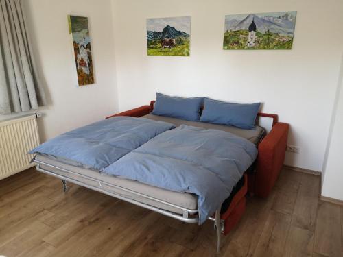 1 cama en una habitación con 2 cuadros en la pared en Ferienwohnung Beim Schuster, en Hitzleried