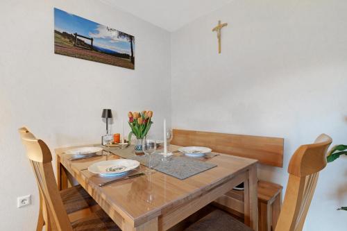 a dining room with a wooden table and a cross on the wall at Schwarzwaldliebe in Oberharmersbach