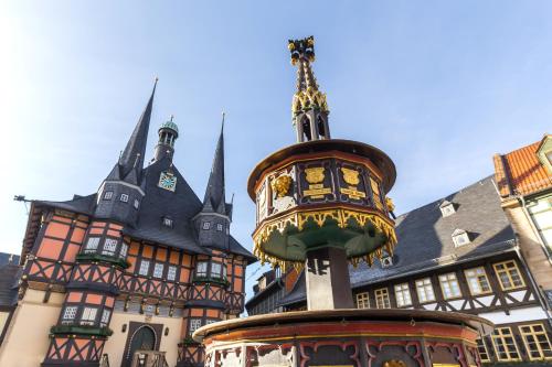 a building with a clock tower in front of it at REGIOHOTEL Bunte Stadt in Wernigerode