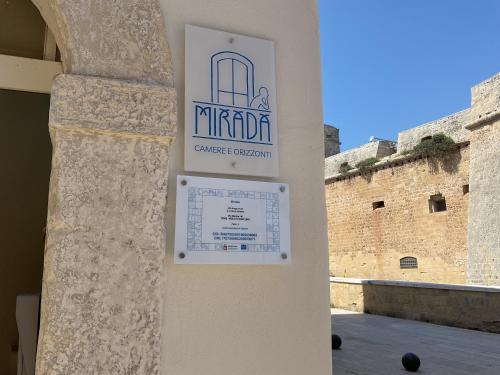 a sign on a wall in front of a building at Mirada in Mola di Bari