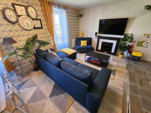 a living room with a blue couch and a fireplace at L'@ppart in Châtillon-sur-Chalaronne