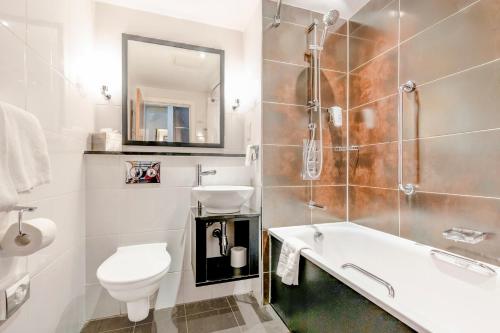 a bathroom with a tub and a sink and a toilet at The Landmark Hotel and SPA Leisure Club Dundee By Sunday in Dundee