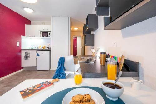 a table with a plate of cookies on it in a kitchen at Résidence Nemea Clermont Centre in Clermont-Ferrand
