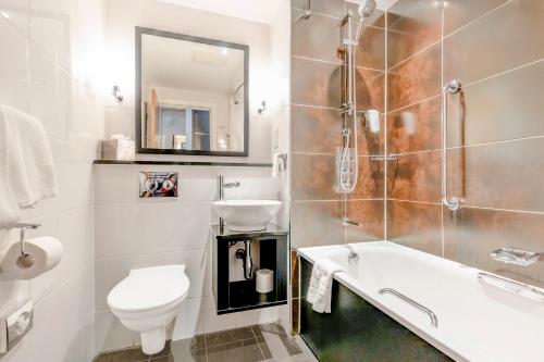 a bathroom with a sink and a toilet and a tub at The Landmark Hotel and SPA Leisure Club Dundee By Sunday in Dundee