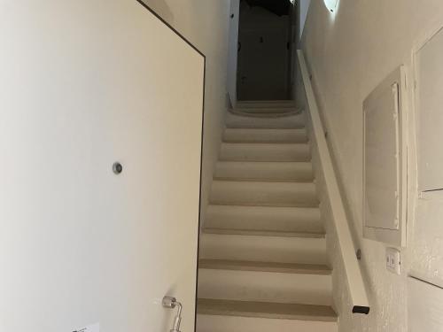 a stairway leading up to a hallway with white stairs at Mirada in Mola di Bari