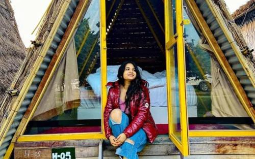 a woman sitting on the stairs of a building at Rural Sense Organic Farm Stay in Faridabad