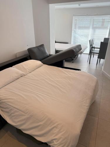 a bedroom with a bed and a chair and a table at Coastal Plaza in Blackpool