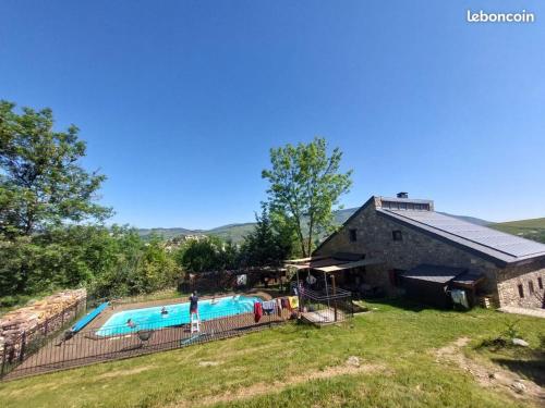 une piscine extérieure à côté d'une grange dans l'établissement Les jardins de l'Orri, à Planès
