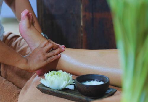 a person with their foot on a table with a bowl of rice at Angkor Home 27 in Phumĭ Réach Born