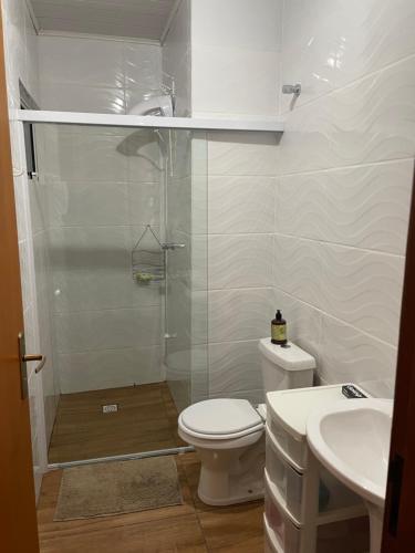 a bathroom with a shower and a toilet and a sink at Chácara Passaúna in Curitiba