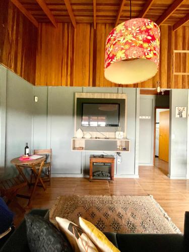 a living room with a couch and a chandelier at Chácara Passaúna in Curitiba