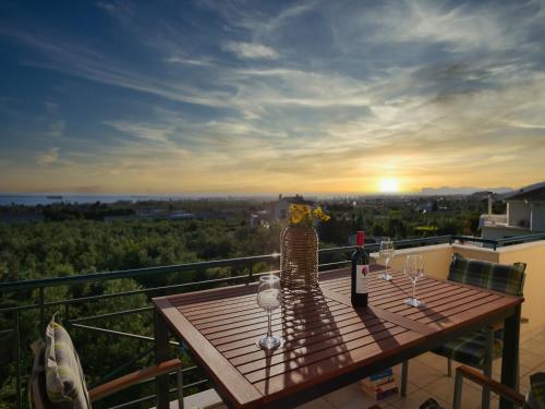 a table with glasses and a bottle of wine on a balcony at Olive Heaven in Kalamata