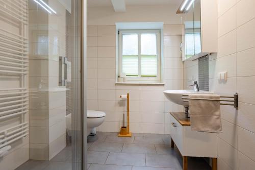 a white bathroom with a sink and a toilet at Stall in Lehde