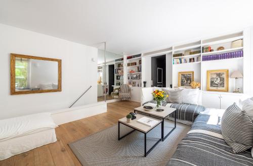 un salon blanc avec un canapé et une table dans l'établissement Louvre l Souplex à 15min du Jardin du Luxembourg, à Paris