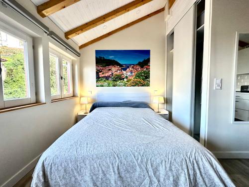 a bedroom with a bed with a painting on the wall at Mirada al mar Cudillero in Cudillero