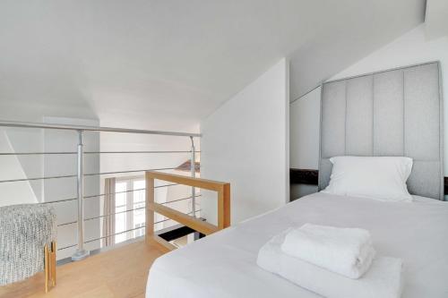 une chambre avec un lit blanc et un escalier dans l'établissement Charming 2BR - 5P - Eiffel Tower - Trocadero, à Paris