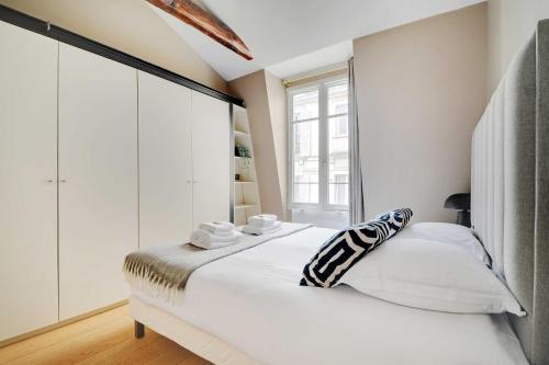 - une chambre blanche avec une grande fenêtre et un lit dans l'établissement Charming 2BR - 5P - Eiffel Tower - Trocadero, à Paris