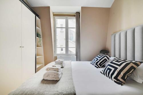 une chambre avec un lit avec des serviettes dessus dans l'établissement Charming 2BR - 5P - Eiffel Tower - Trocadero, à Paris