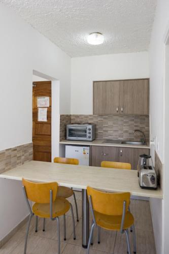 a kitchen with a table and four chairs at Alecos Hotel Apartments in Paphos