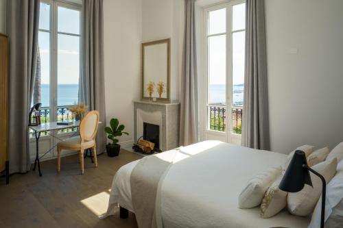 a bedroom with a bed and a desk with a fireplace at Villa Fantaisie in Menton