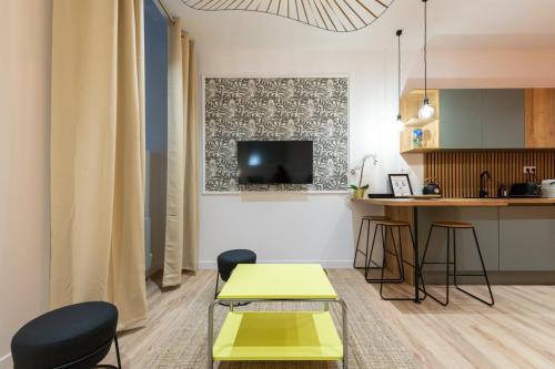 un salon avec deux tables et une télévision dans l'établissement Lassagne - 3, à Lyon
