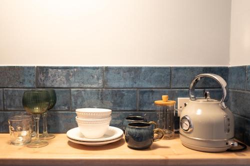 a counter with a tea kettle and cups and glasses at The Hall - Historic Grade I-listed Jacobean Mansion in Bradford on Avon