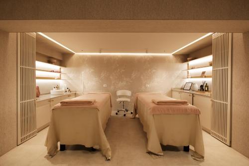 a room with two beds and a table at Palace Hotel & SPA in Durrës