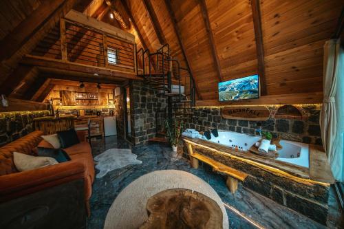 a living room with a fireplace in a log cabin at Waterfall suit bungalov in Çamlıhemşin