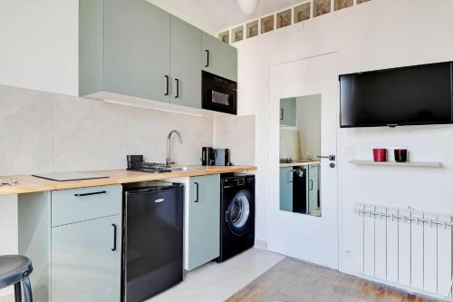 une cuisine avec un évier et un lave-vaisselle dans l'établissement Ideal studio for 2 people - Marché des Batignolles, à Paris