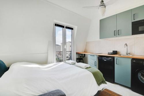 une chambre avec un grand lit blanc et une fenêtre dans l'établissement Ideal studio for 2 people - Marché des Batignolles, à Paris