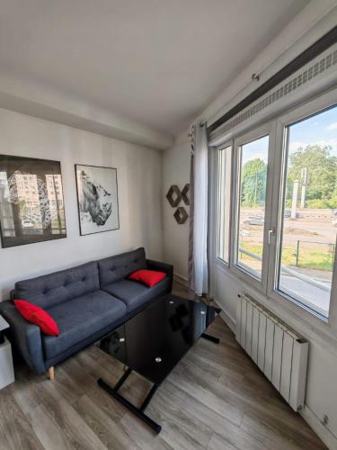 a living room with a couch and a window at Cozy Apartment Montrouge Paris in Montrouge
