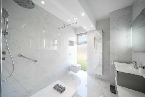 une salle de bain blanche avec une douche et un lavabo dans l'établissement Renovated apartment 155m2 3BR6p - Cannes Palm Beach, à Cannes