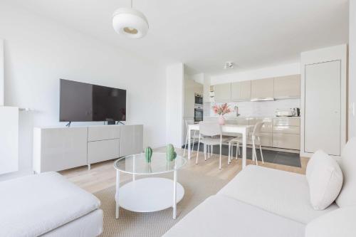 un salon blanc avec un canapé blanc et une table dans l'établissement Classy apartment - Flea Market, à Saint-Ouen