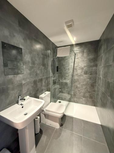 a bathroom with a sink and a toilet and a shower at Coastal Plaza in Blackpool