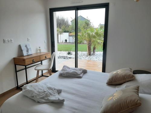 2 camas en un dormitorio con escritorio y ventana en Carpe Diem, en Jullouville-les-Pins
