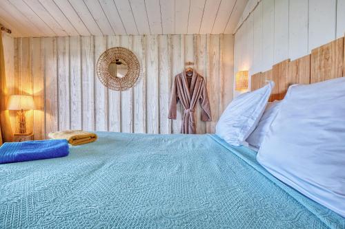 a bedroom with a large bed with blue sheets at Les cabanes de Monbazillac in Monbazillac