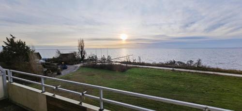 een uitzicht op de oceaan vanuit een huis met een hek bij Vier Jahreszeiten Möwenblick in Großenbrode-Kai