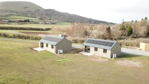 two houses with solar panels on them in a field at Loganlea Lodge in Loanhead