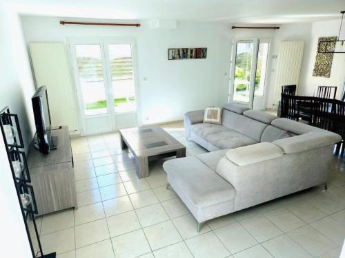 a living room with a couch and a coffee table at Maison Familiale & Confortable proche Plage in Luc-sur-Mer