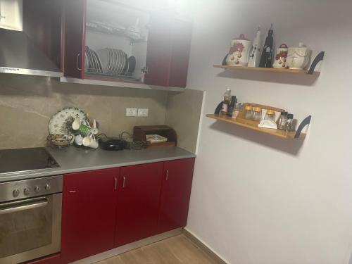 eine Küche mit roten Schränken und einer Arbeitsplatte in der Unterkunft VIEW apartment in Sarandë
