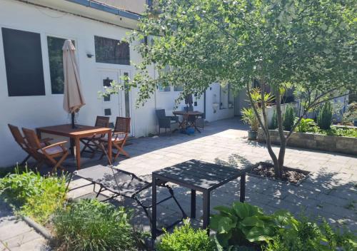 a patio with a table and chairs and an umbrella at Silver Dream Apartmanház in Debrecen