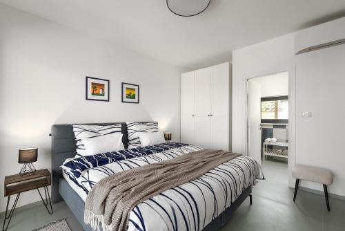 a white bedroom with a large bed and a chair at Casa Estelle & Andrea in Drenje