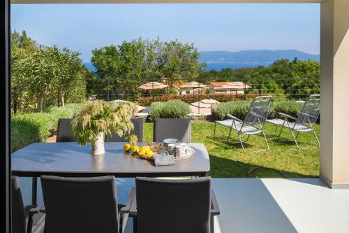 a patio with a table and chairs and a garden at Casa Estelle & Andrea in Drenje