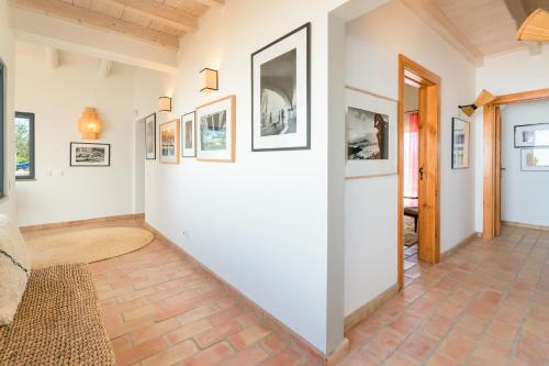a hallway with pictures on the walls of a house at Monte da Torre in Melides