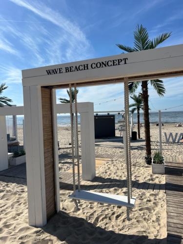 a sign that reads wave beach concept on the beach at Waveview Premium Apartment Międzyzdroje in Międzyzdroje