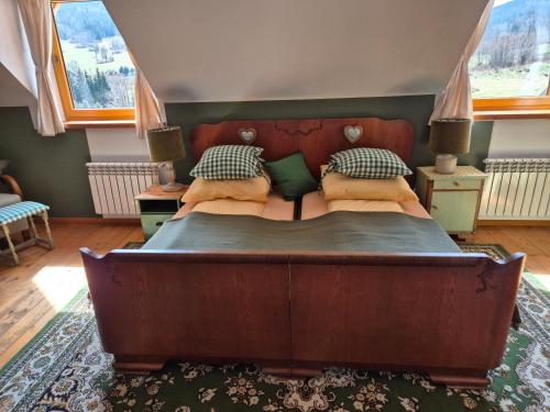 a bedroom with a large wooden bed with pillows at Miodówka in Stronie Śląskie