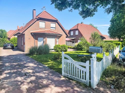 a white fence in front of a house at Holiday Home Christa - HOK110 by Interhome in Hooksiel